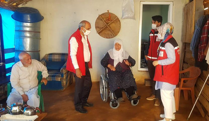 Yaşlı ve engelli kadına tekerlekli sandalye desteği